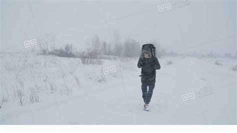 Young Man Walking Through A Snowstorm Stock Video Footage 11546318