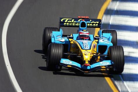 A Blue And Yellow Race Car Driving Down The Road