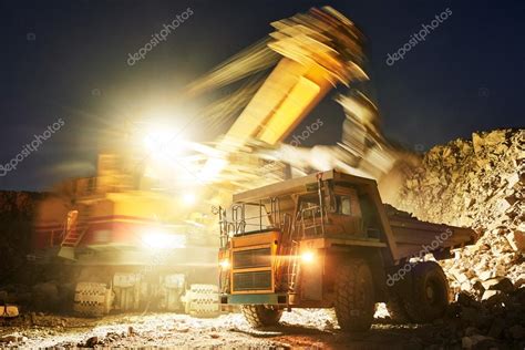 Mining Excavator Loading Granite Or Ore Into Dump Truck Stock Photo