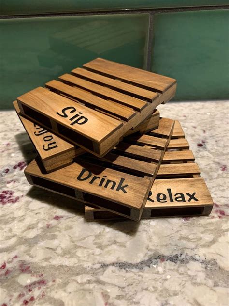 Three Wooden Coasters With Words On Them Sitting On A Counter Top Next