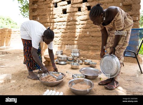 Dans cette image deux jeunes femmes noires préparent un repas pour les