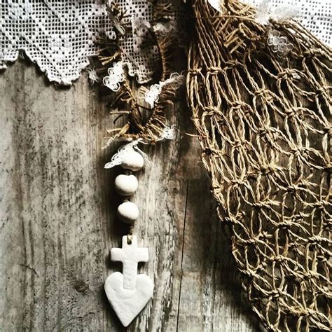 A White Cross Is Sitting On A Piece Of Wood Next To A Lace Doily