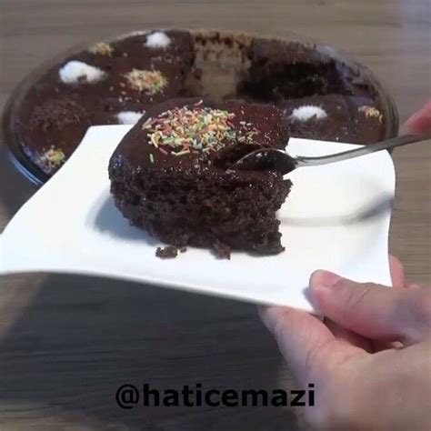 A Person Cutting Into A Chocolate Cake With A Knife And Fork On A White