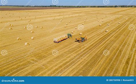 Aerial View Of Agricultural Field Collecting Round Bales Of Straw