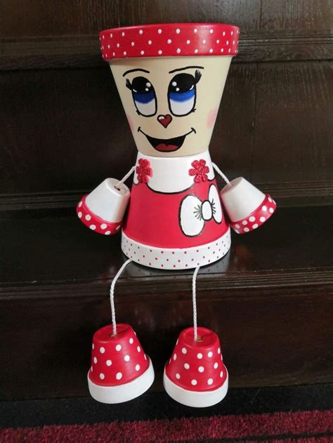 A Red And White Doll Sitting On Top Of A Wooden Floor Next To A Brown Door