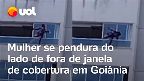 Mulher se pendura em cobertura de prédio para limpar janela e ação