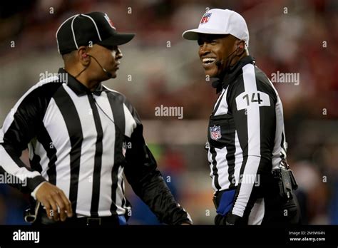 Referee Shawn Smith (14) and down judge Patrick Holt (106) converse ...