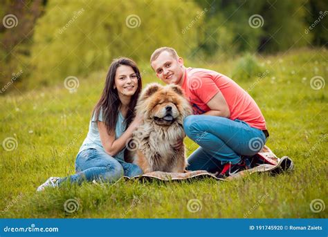 Pareja Joven Con Perros En El Parque Foto De Archivo Imagen De