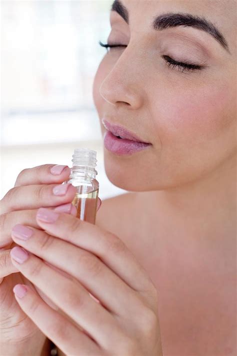 Woman Smelling Liquid In Small Glass Bottle Photograph By Ian Hooton Science Photo Library