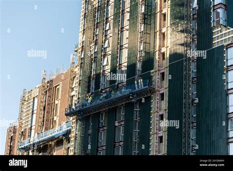Workers On A Lift At Height Working On The Construction Of A Tall