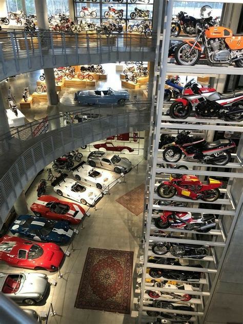 There Are Many Cars And Motorcycles On Display In The Building With