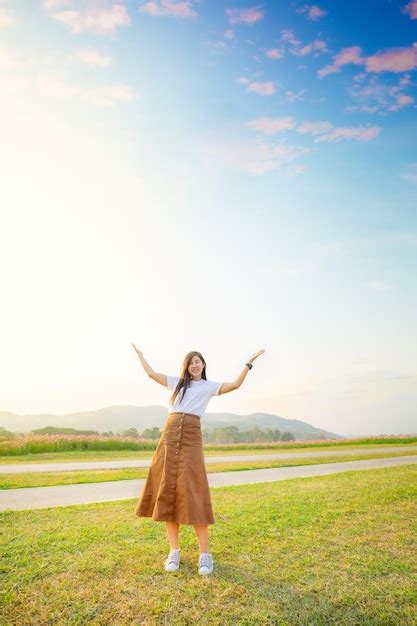 Premium Photo Young Woman In White Dress Standing On Green Grass Over