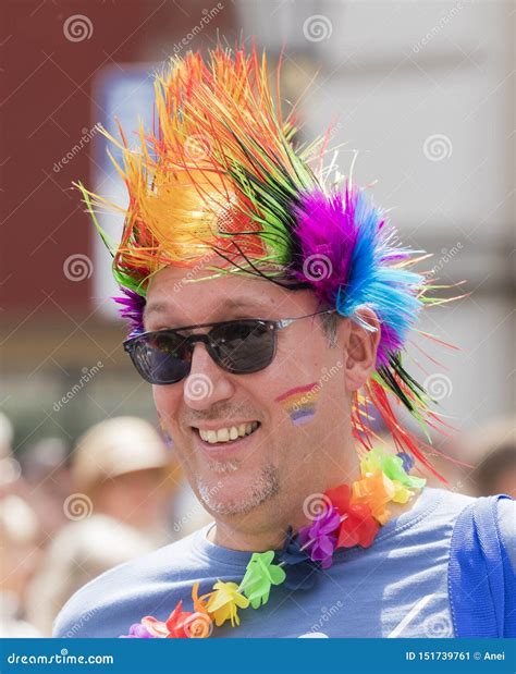 A Smiling Gay Man With A Rainbow Wig Attending The Gay Pride Parade