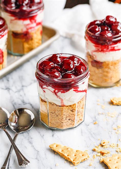 Two Jars Filled With Dessert Sitting On Top Of A Counter Next To