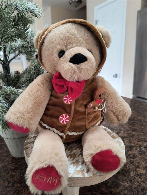 A Teddy Bear Wearing A Brown Jacket And Red Bow Tie Sitting On Top Of A