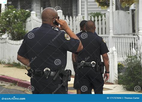 Two Police Officers Investigate A Situation Editorial Stock Image