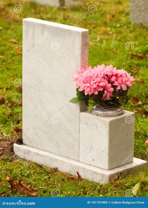 White Marble Gravestone From Behind With Pink Flowers Cemetery Stock