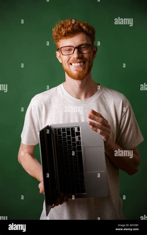 Cheerful Readhead Bearded Man In Glasses And White Tshirt Holding