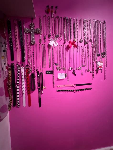 A Pink Wall Filled With Lots Of Different Types Of Necklaces And