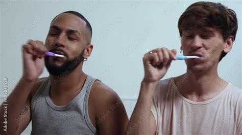 Jovem Casal Gay Inter Racial Brasileiro No Banheiro Escovando Os Dentes Juntos Sentados Na