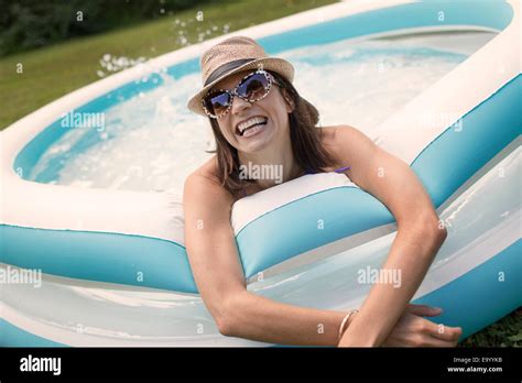 Mature Woman In Paddling Pool Splashing Water Stock Photo Alamy