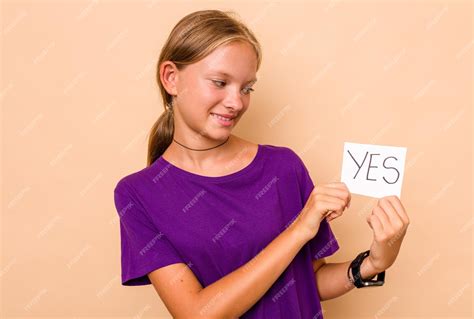 Premium Photo Little Caucasian Girl Holding Yes Placard Isolated On Beige Background