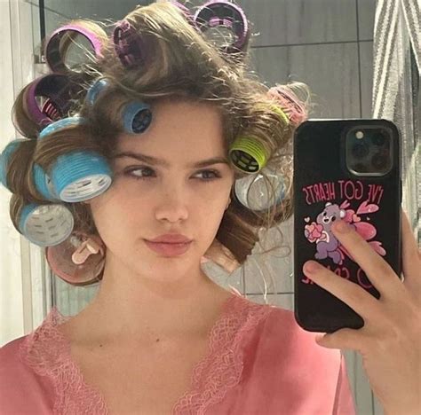 A Woman Taking A Selfie With Her Hair In Rollers On Her Head While