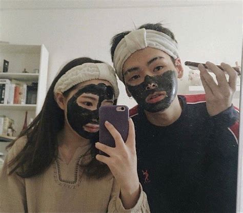 Two People With Facial Masks On Taking A Selfie