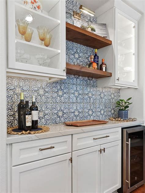 A Kitchen With White Cabinets And Blue Tile Backsplashing On The