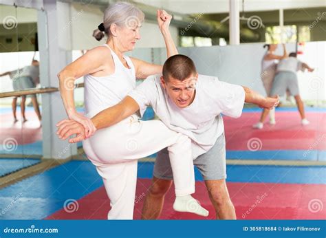 Mature Woman Performing Knee Strike During Self Defence Training Stock