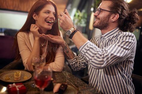 A Young Guy Feeding His Girlfriend At Valentine`s Day Celebration At A