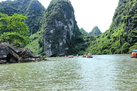 Some People Are Rafting Down A River With Mountains In The Background