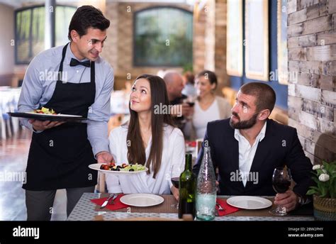 Waiter Worker Male Bringing Food For People Of Adult Smiling Guests