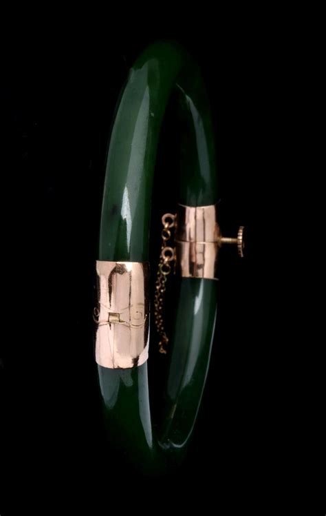 #218: A GREEN JADE AND 14K GOLD BANGLE BRACELET