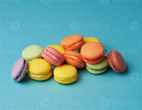 Stack Of Multi Colored Round Baked Macarons Cakes On A Blue Background