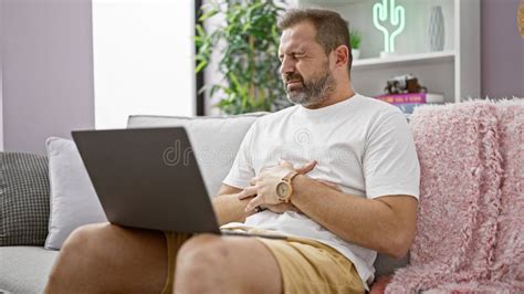 Mature Hispanic Man With Grey Hair Experiences Stomach Ache While Using