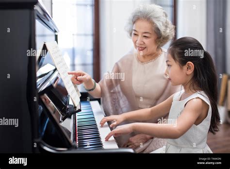 Grandmother Teaching Granddaughter To Play The Piano Stock Photo Alamy