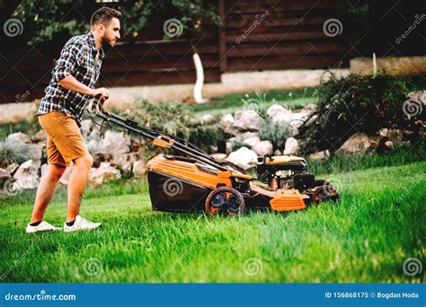 Gardener Mowing The Lawn Using A Professional Lawnmower Stock Image