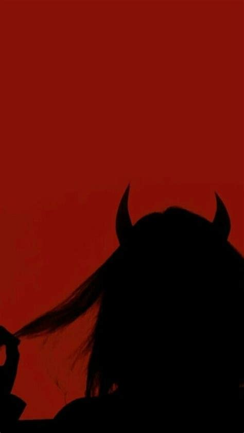 The Silhouette Of A Woman With Long Hair And Horns On Her Head Against