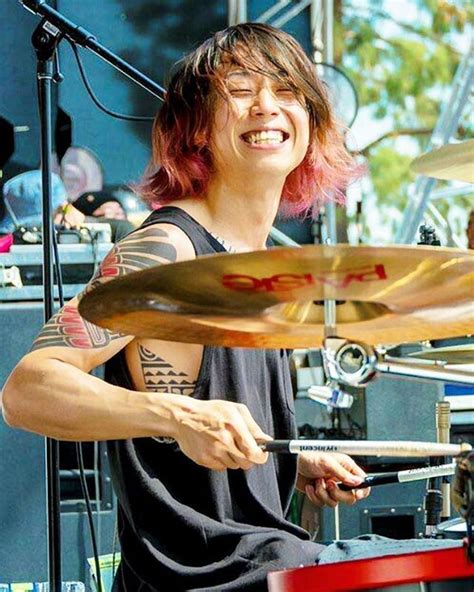 A Man With Pink Hair Playing The Drums