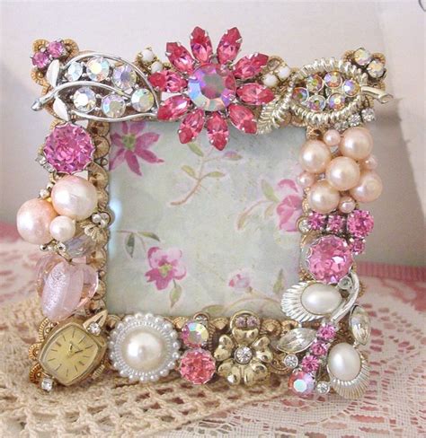 An Ornate Photo Frame With Pink Flowers And Pearls