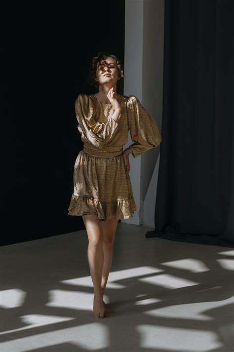 Brunette Woman Wearing A Golden Mini Dress With Flared Sleeves · Free