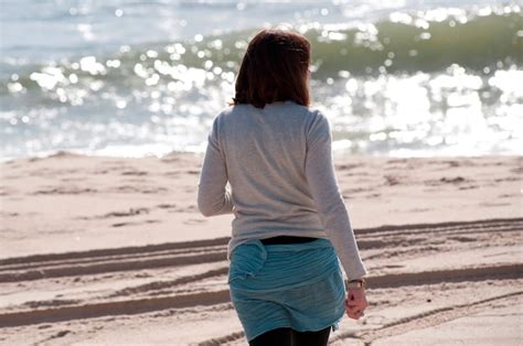 Vista Traseira De Um Mulher Caminhando Ao Longo A Praia Em A