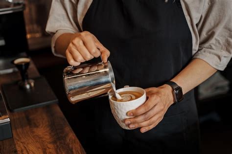 Premium Photo Barista Pouring Milk Into Coffee Cup