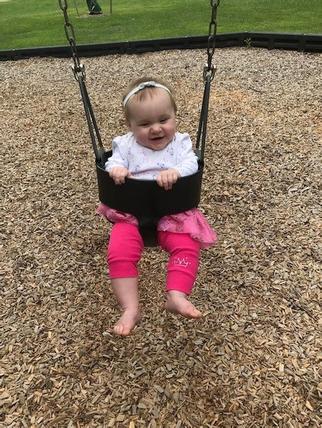 Premium Photo | Full length of cute baby girl sitting on swing at ...