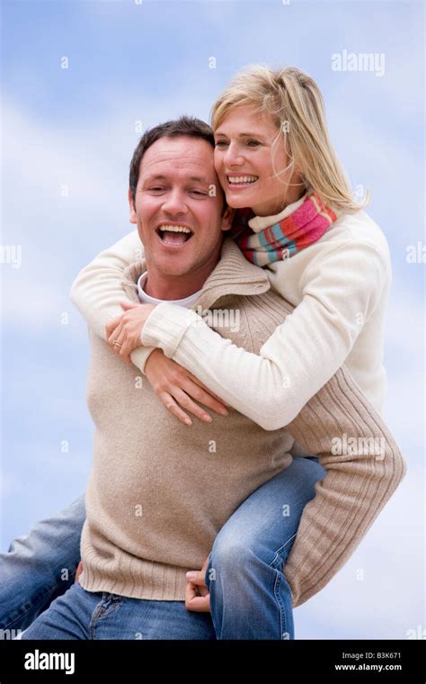 Man Giving Woman Piggyback Ride Outdoors Smiling Stock Photo Alamy