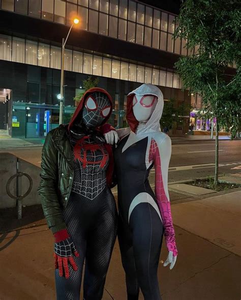 Two People Dressed Up As Spider Man And Woman