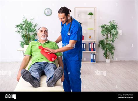 The Old Man Visiting Young Male Doctor Gastroenterologist Stock Photo