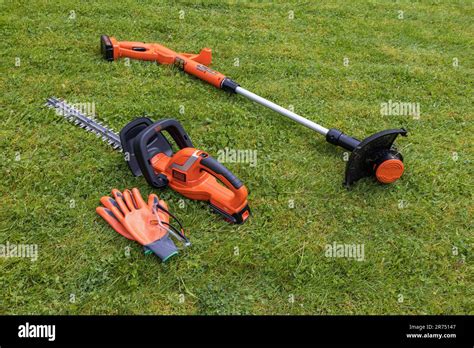 Black And Decker Cordless Hedge Trimmer And Cordless Lawn Trimmer Lie On The Lawn Lawn Care