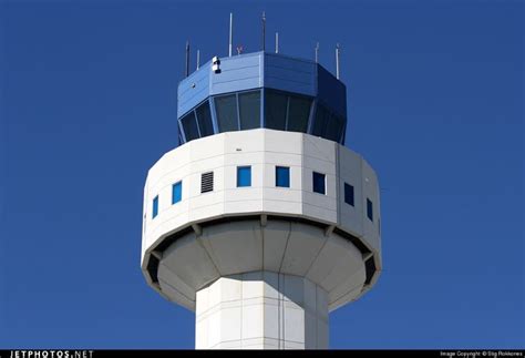 the top of an airport control tower with blue sky in the backgrounnd